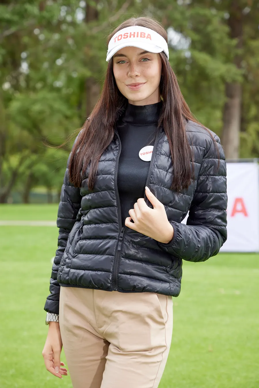 Cobertura de campaña para Toshiba: edecán con visera y chamarra de la marca en un campo de golf