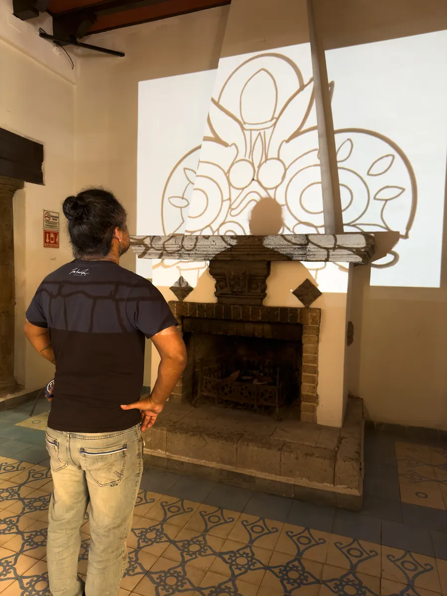 Diseño del logo proyectado sobre la pared del restaurante antes de pintarlo, revisado por el muralista