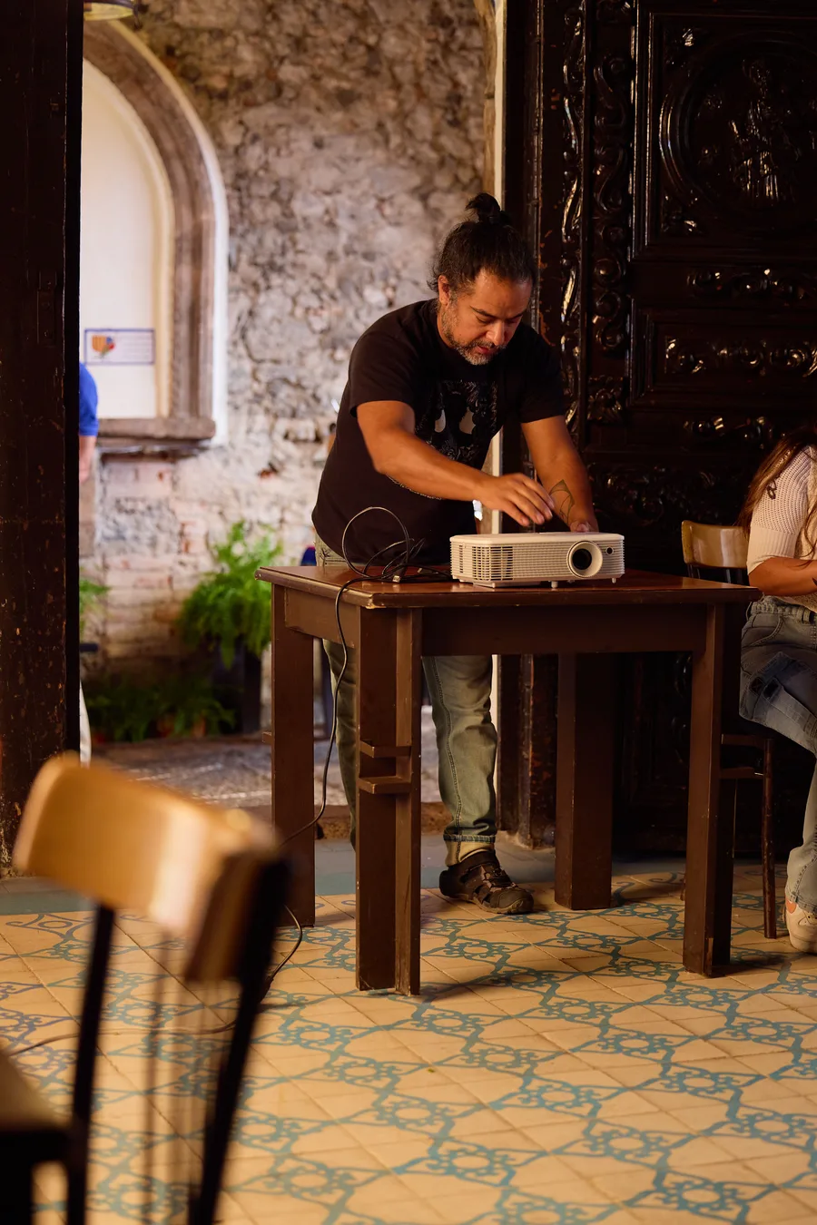 Montaje del proyector sobre una mesa de madera en el salón de El Garrobo, antes de trazar el mural