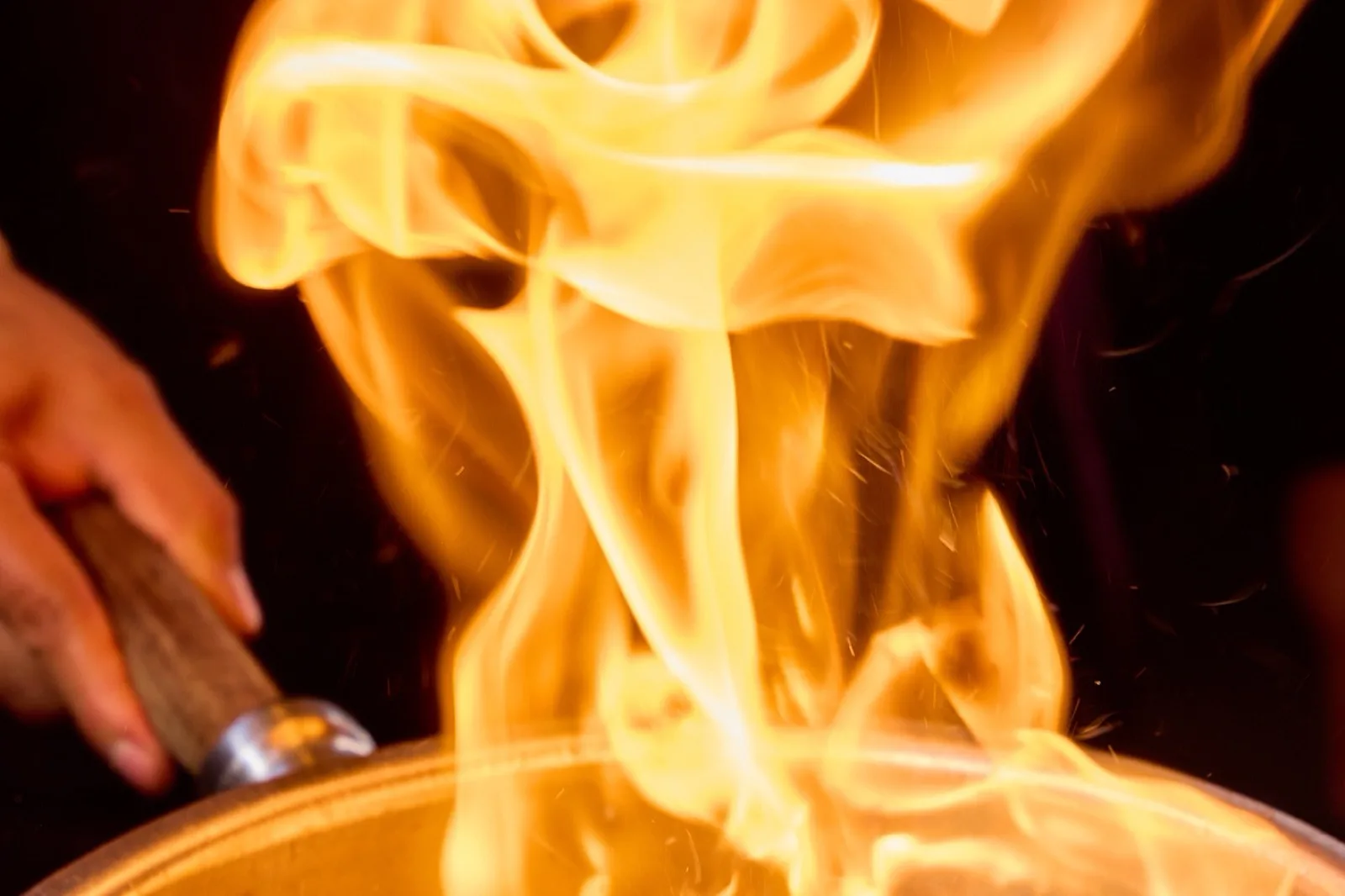 Flambeado en la mesa: el fuego levantándose del sartén, en pleno servicio