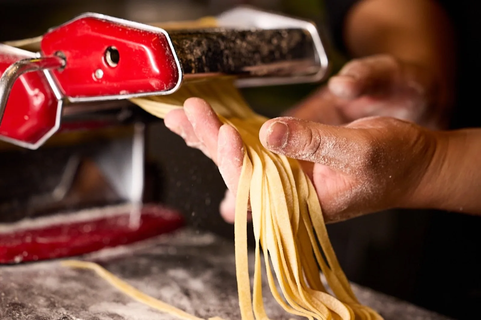 Manos estirando pasta fresca sobre el mármol de la cocina de Cabo Coyote