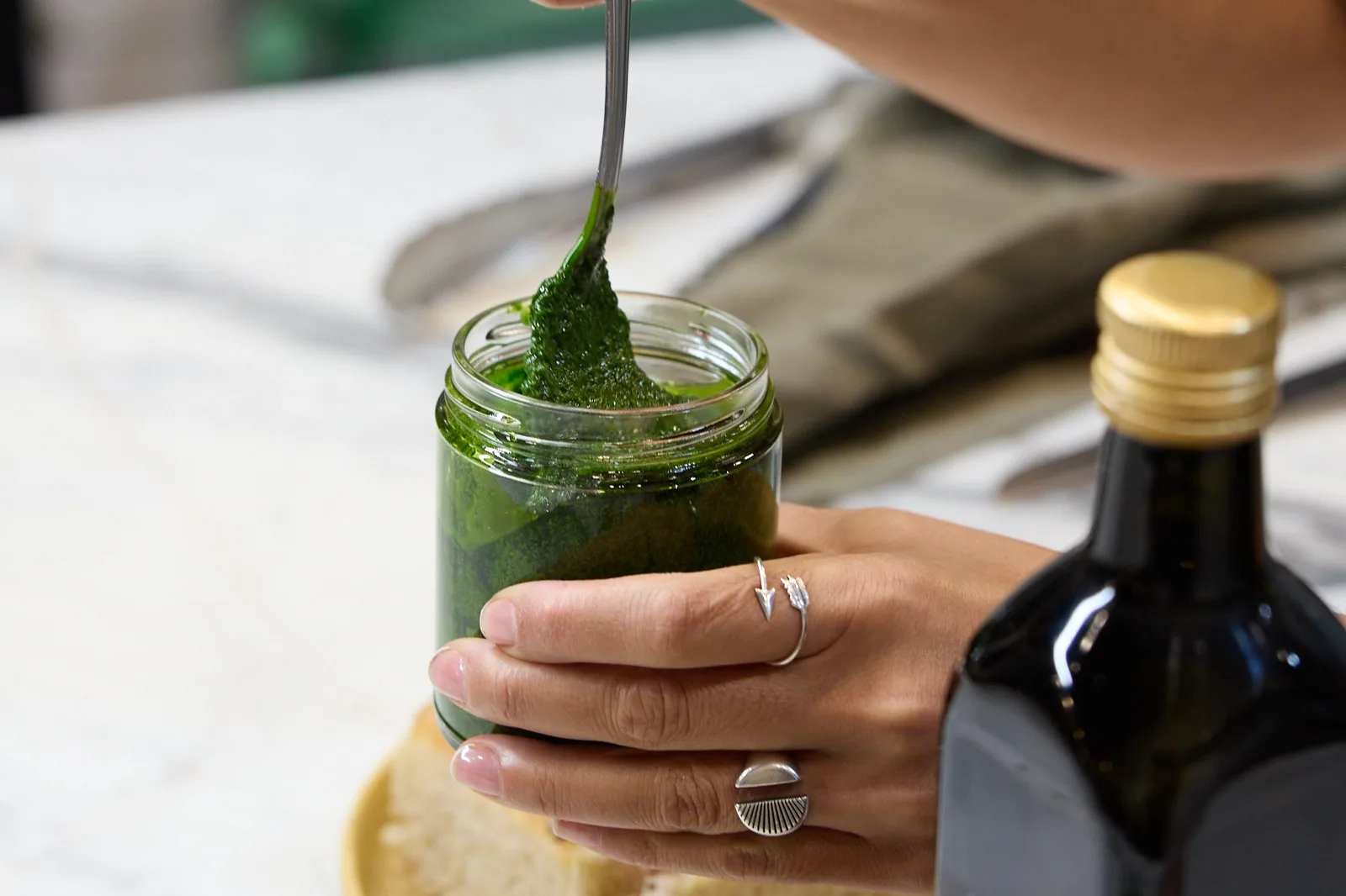 Manos vertiendo salsa verde en la cocina de Delirio